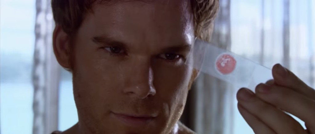 Dexter Morgan observe goutte de sang dans lamelles en verre.